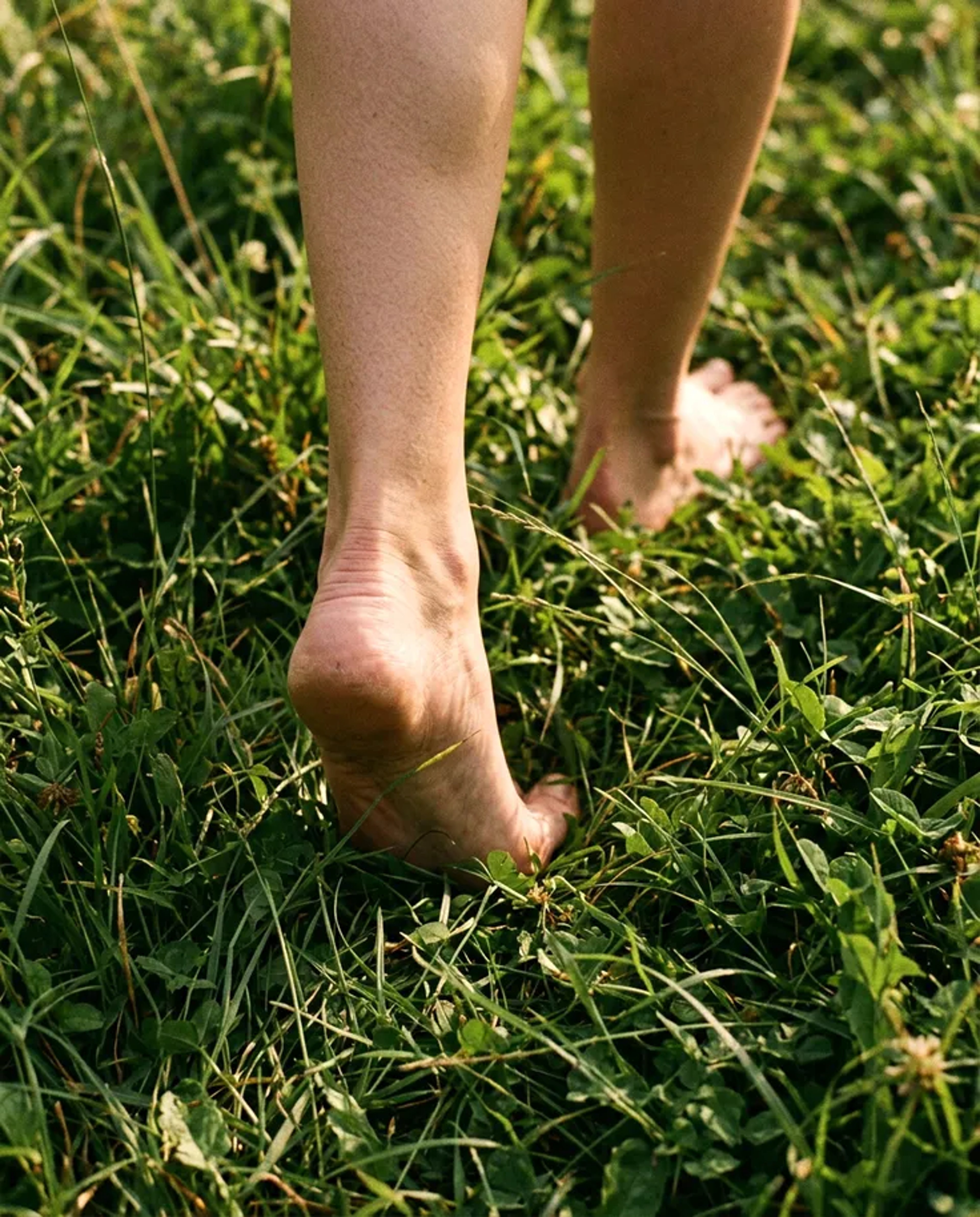 Bare feet standing in grass, representing groundedness and presence